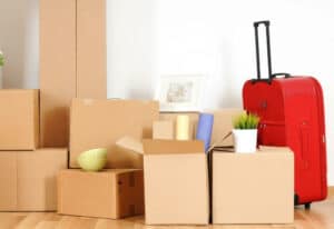 scatoloni e imballi per il trasloco nazionale/internazionale in una stanza e una valigia rossa