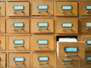 cassetti di un archivio contenenti documenti cartacei chiusi con un cassetto aperto 