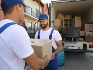 Traslocatori durante il carico dei mobili e degli scatoloni sul furgone per traslochi