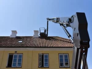 utilizzo di una piattaforma aerea per lavori di manutenzione sul tetto di una casa