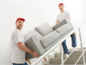 traslocatori professionisti trasportano un divano per le scale
