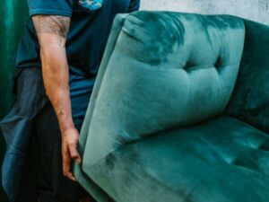 Operaio solleva un vecchio divano per lo sgombero e il trasporto