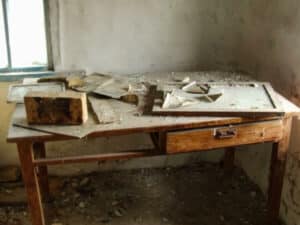 Vecchia scrivania in un locale abbandonato per lo sgombero e lo smaltimento