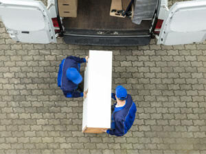 due operai trasportano un mobile per trasloco ufficio