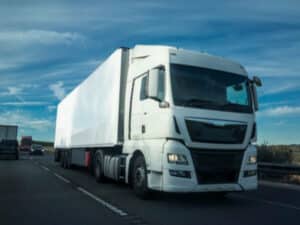 camion bianco su una strada per il trasloco internazionale via terra