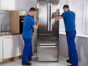 due operai spostano un frigorifero per il trasloco